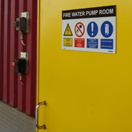 A bespoke safety sign with safety symbols and text on a sliding door of an offshore platform.