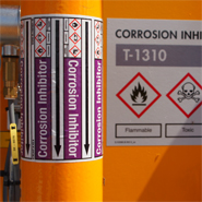 A pipe marker with medium color, GHS symbols, flow direction and description to provide insight to the production process.